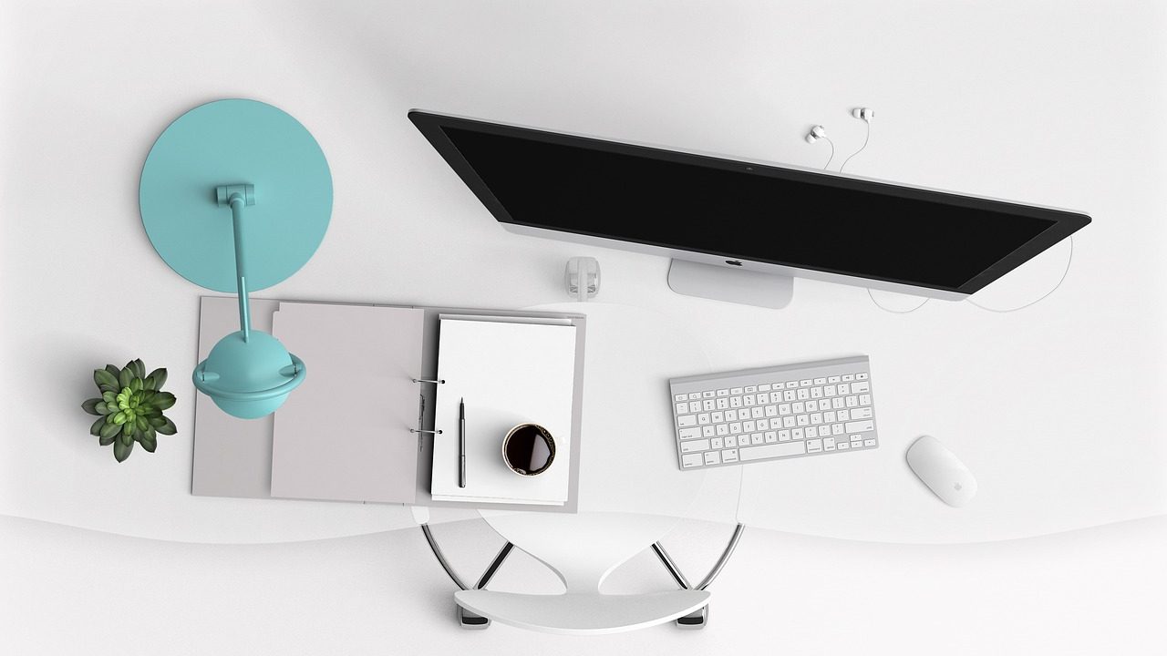 top down view of computer and notebook at someone's desk