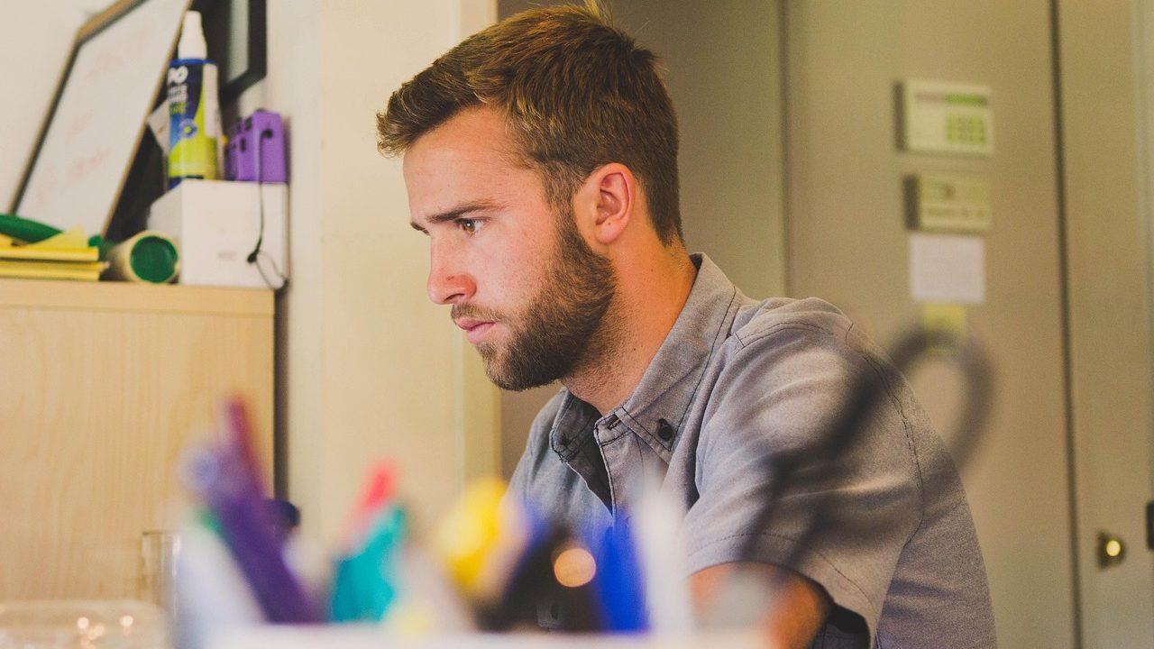 man staring at computer screen with an apprehensive look