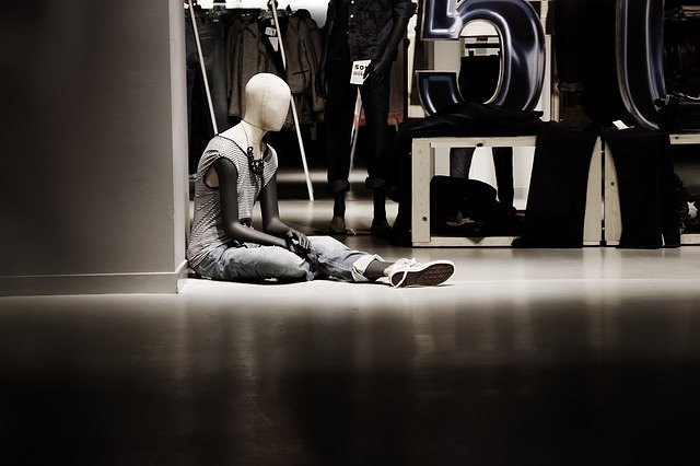 a mannequin in a suit seated on the floor of an office building