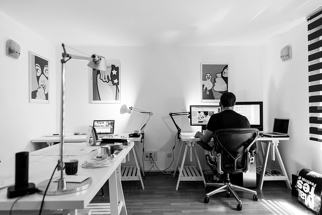 modern home office setup with a man working at his computer in the background