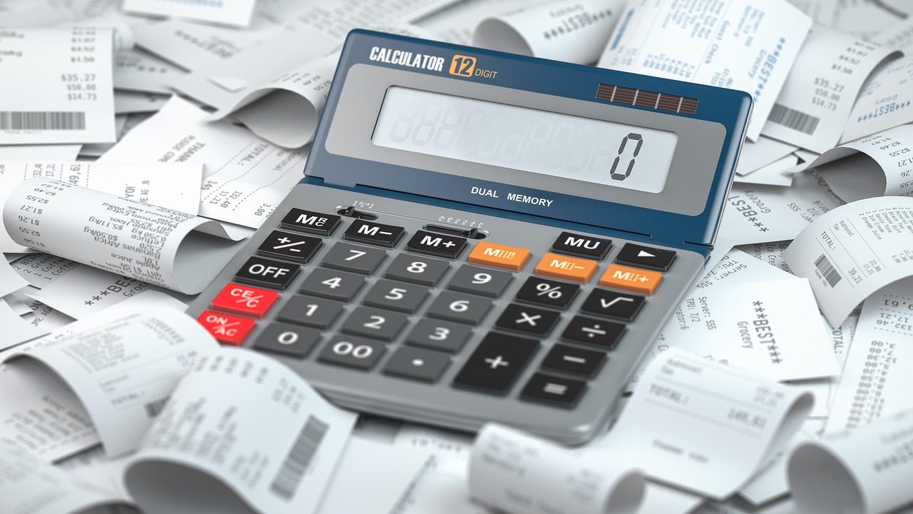 a calculator atop a pile of receipts