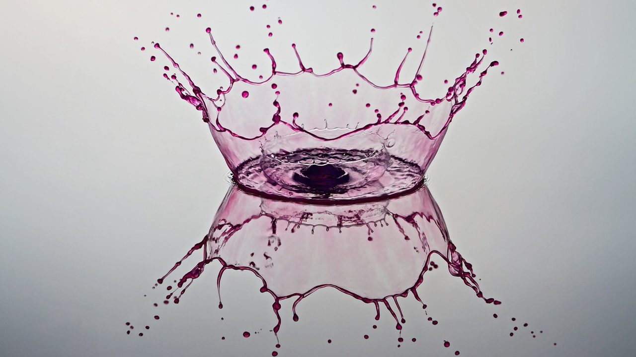 a splash of pink water formulating a crown in the splash