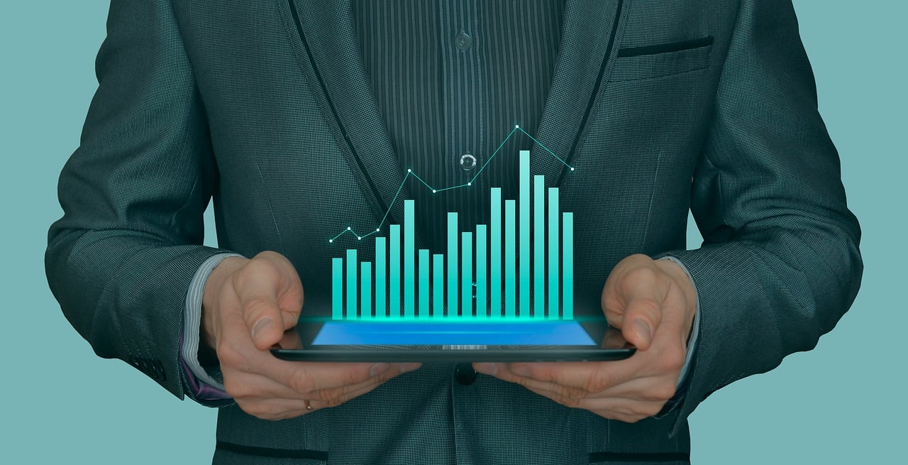close up of a person's torso holding a tablet with a graph popping out