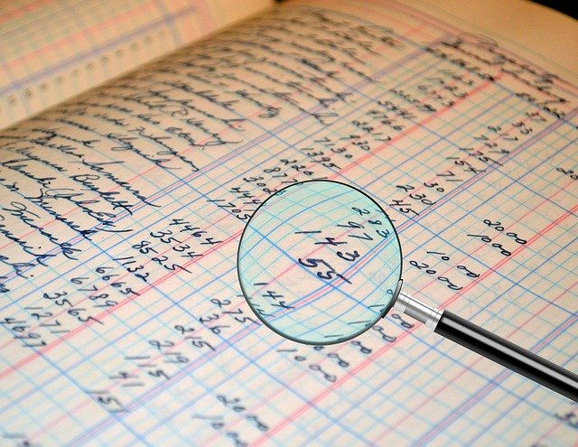 magnifying glass over accounting ledger