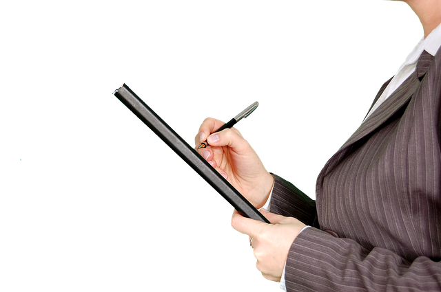 woman signing a document on a clipboard