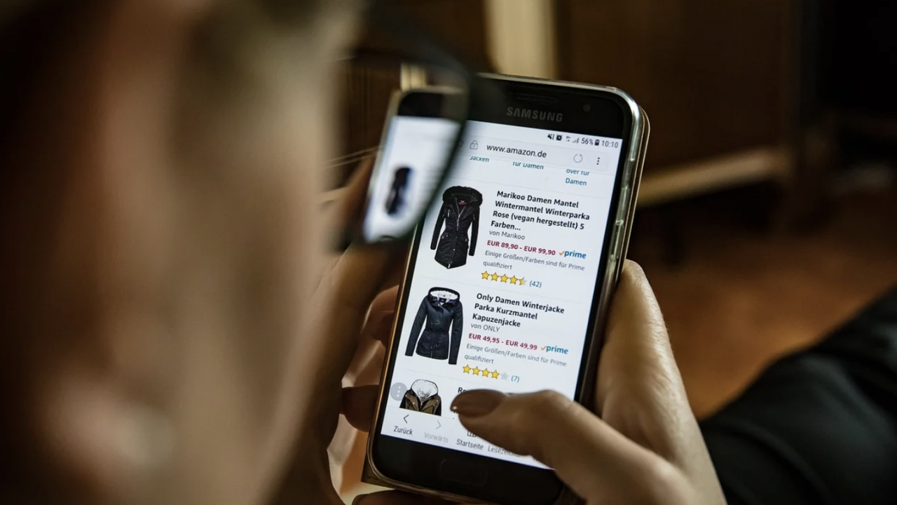 closeup of woman scrolling on her phone looking at clothes for sale